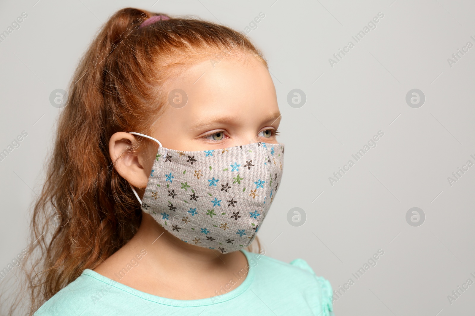 Photo of Preteen girl in protective face mask on light grey background. Space for text