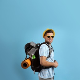 Photo of Male tourist with travel backpack on turquoise background, space for text