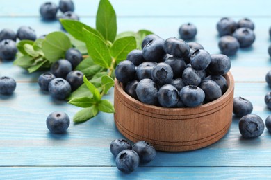 Photo of Tasty fresh blueberries on light blue table, closeup