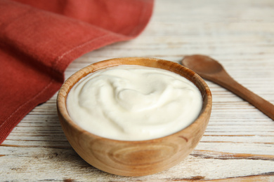 Photo of Tasty organic yogurt on white wooden table