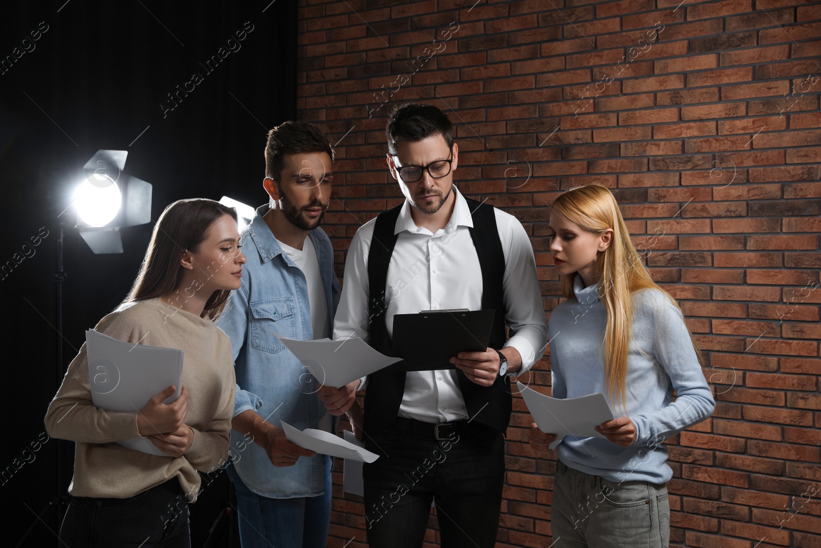 Photo of Professional actors reading their scripts during rehearsal in theatre