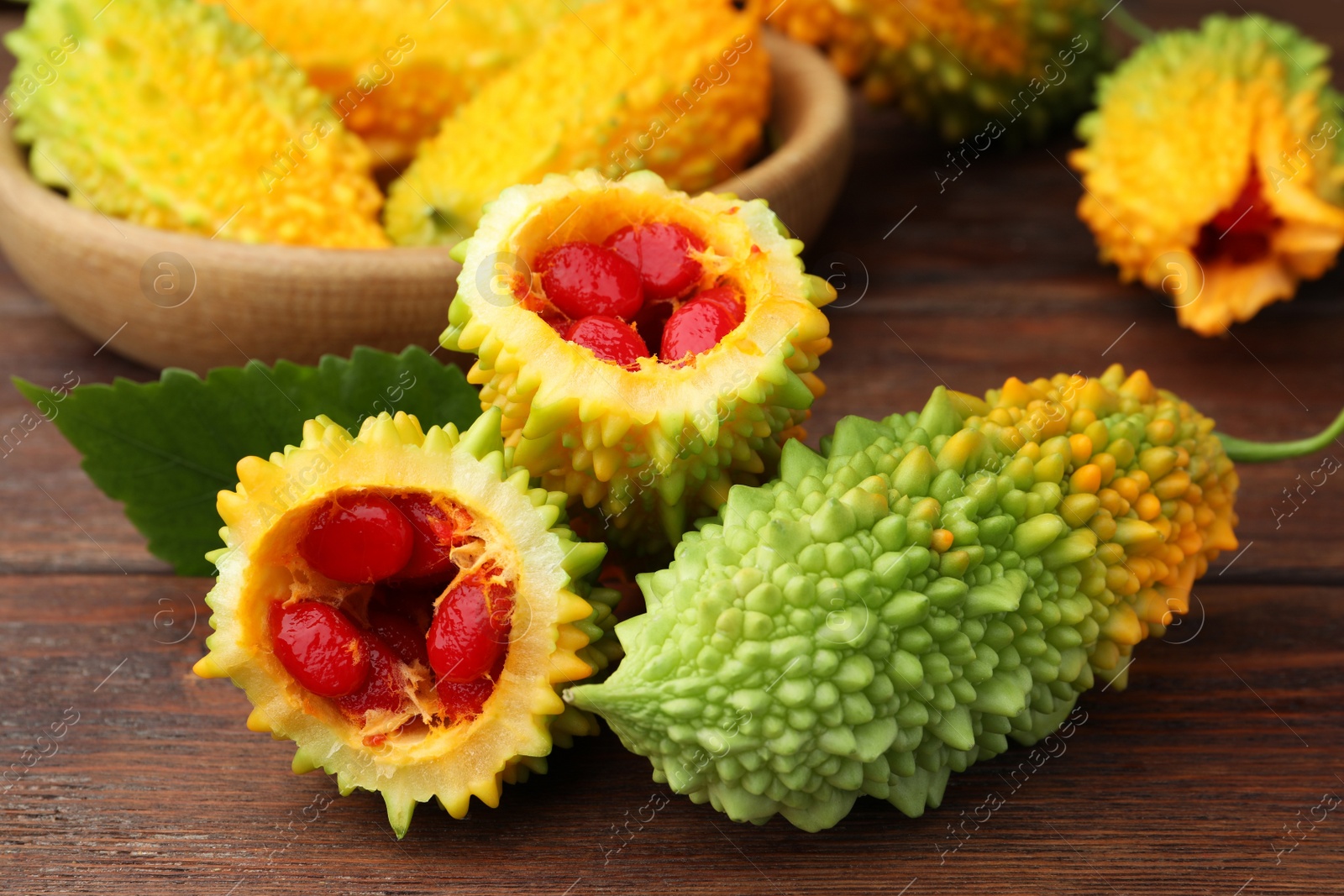 Photo of Fresh bitter melons on wooden table, closeup