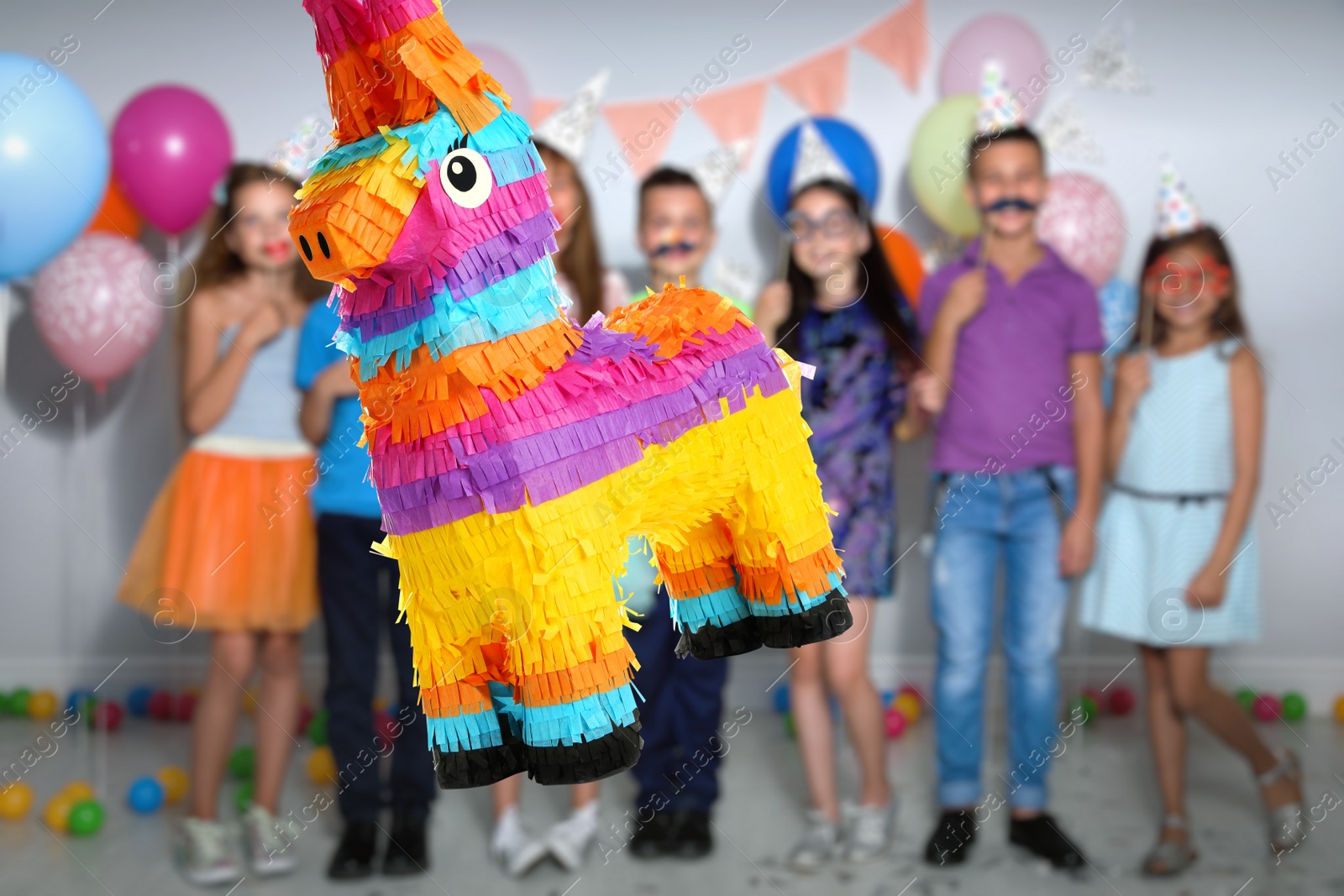 Image of Bright festive pinata hanging indoors at birthday party