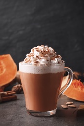 Photo of Delicious pumpkin latte on grey table, closeup