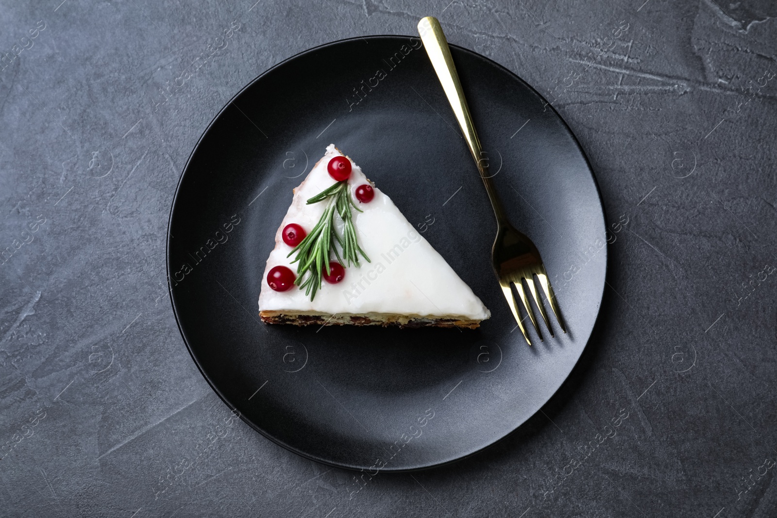 Photo of Slice of traditional Christmas cake served on black table, top view