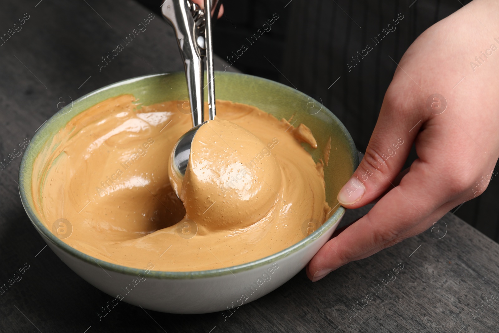 Photo of Woman taking cream from bowl at table, closeup. Making dalgona coffee