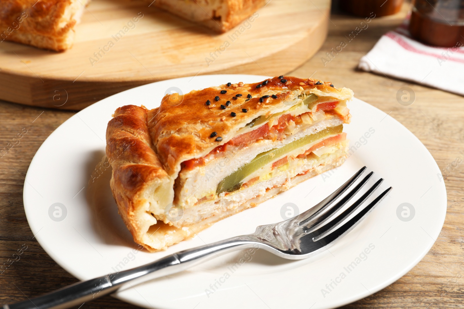 Photo of Piece of tasty homemade pie with filling served on wooden table