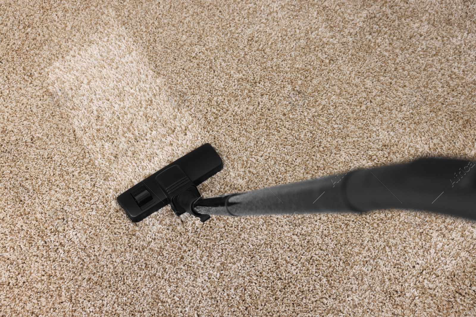 Photo of Hoovering carpet with vacuum cleaner, above view