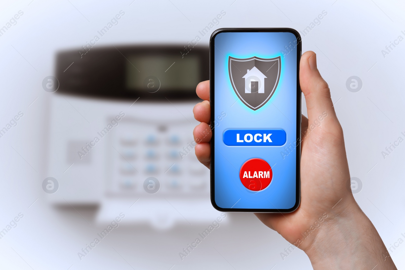 Image of Woman operating home alarm system via mobile phone against white wall with security control panel, closeup. Application interface on device screen