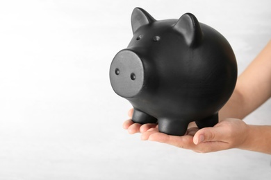 Photo of Woman holding piggy bank on white background, closeup view
