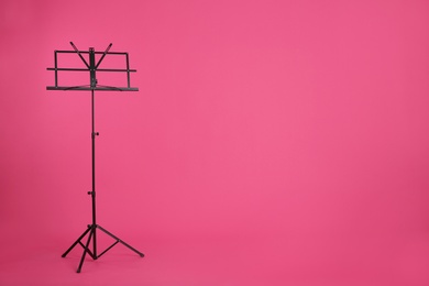Photo of Empty music note stand on color background. Space for text