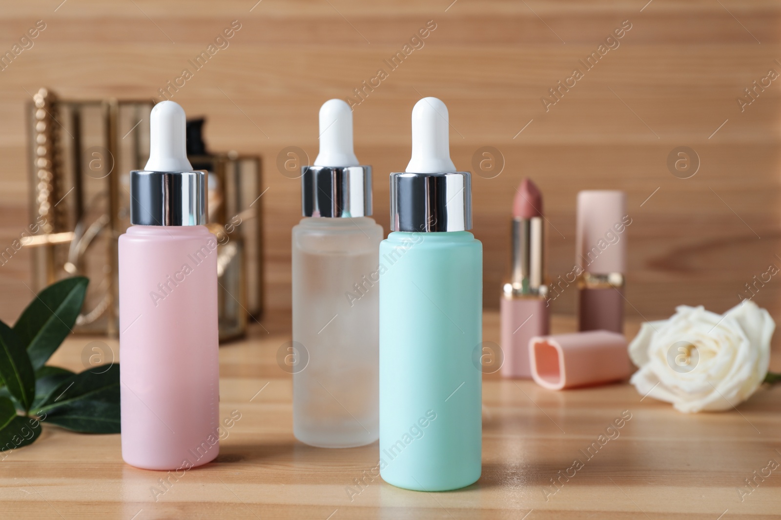 Photo of Bottles of serum on wooden table. Cosmetic products