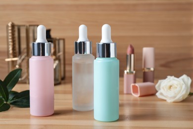 Photo of Bottles of serum on wooden table. Cosmetic products