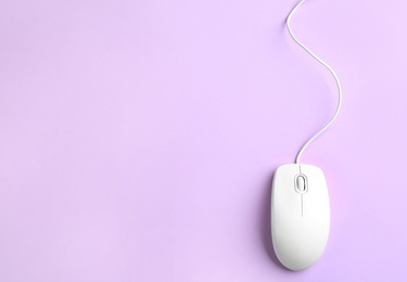 Modern wired optical mouse on lilac background, top view. Space for text