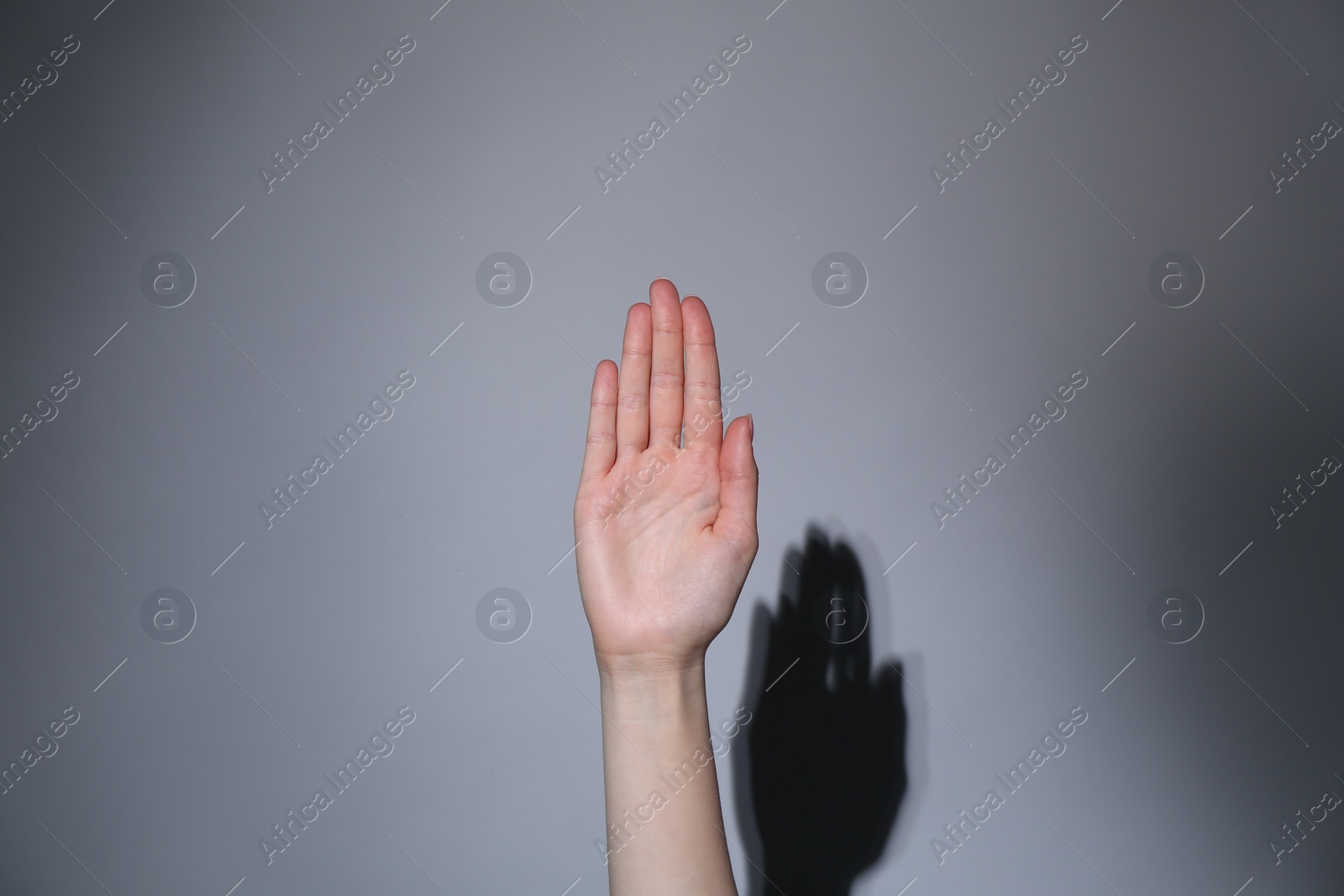 Photo of Woman showing open palm on grey background, closeup