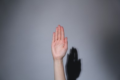 Photo of Woman showing open palm on grey background, closeup