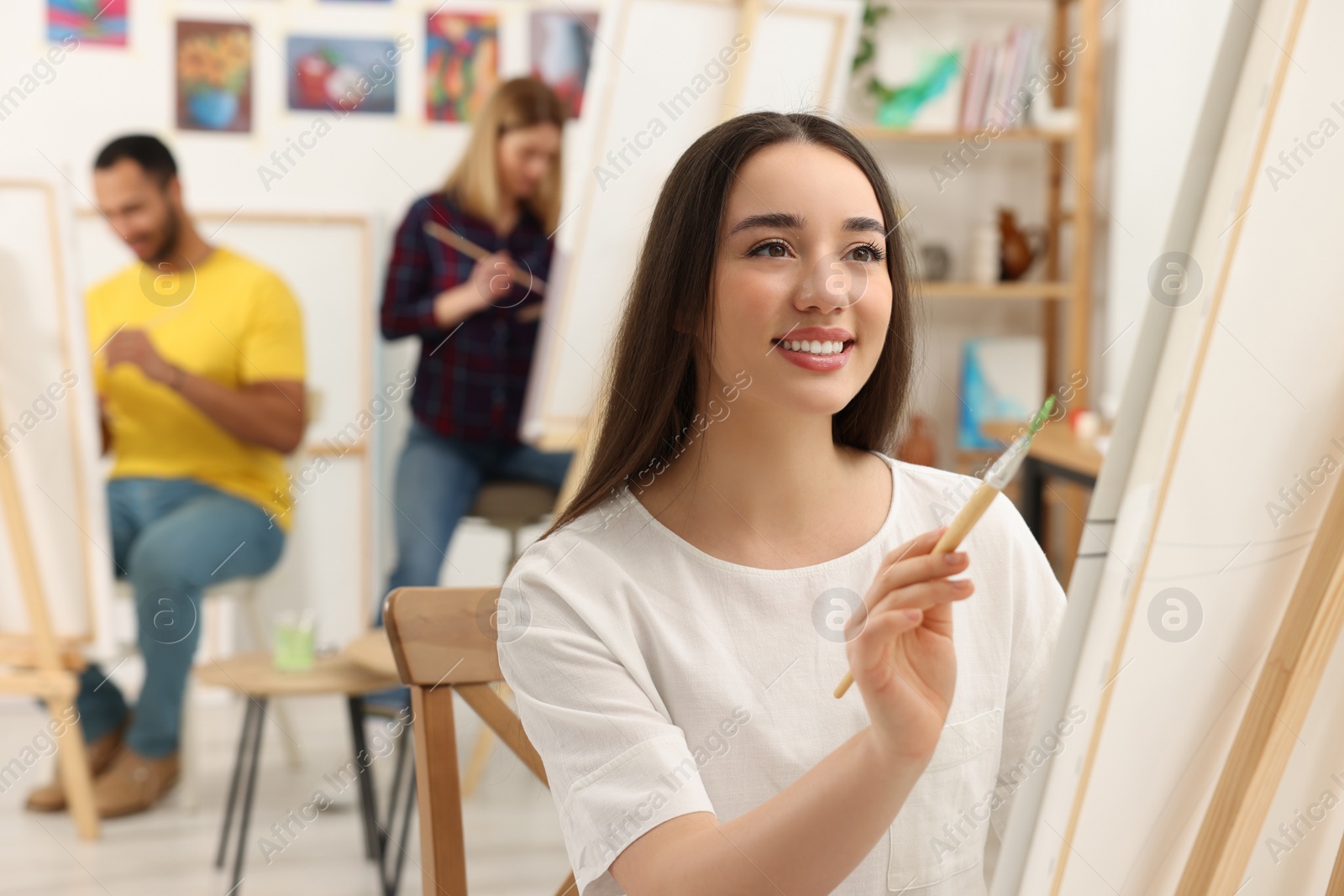 Photo of Group of students attending painting class in studio. Creative hobby