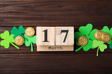 Photo of Flat lay composition with block calendar on wooden background. St. Patrick's Day celebration