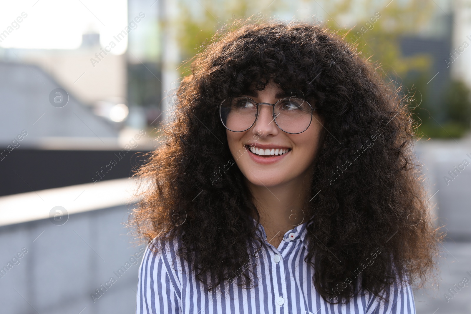 Photo of Portrait of beautiful woman in glasses outdoors. Attractive lady smiling and posing for camera