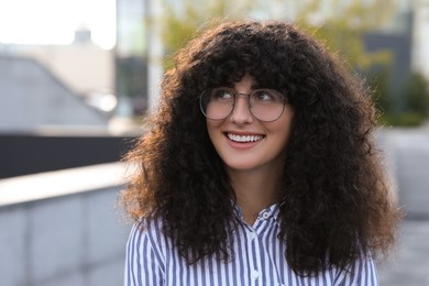 Photo of Portrait of beautiful woman in glasses outdoors. Attractive lady smiling and posing for camera