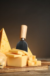 Different sorts of cheese and knife on wooden table