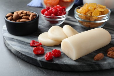 Photo of Marzipan and other ingredients for homemade Stollen on grey table, closeup. Baking traditional German Christmas bread