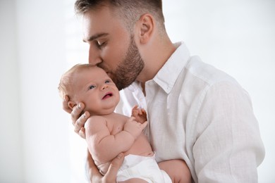 Father with his newborn son on light background, closeup