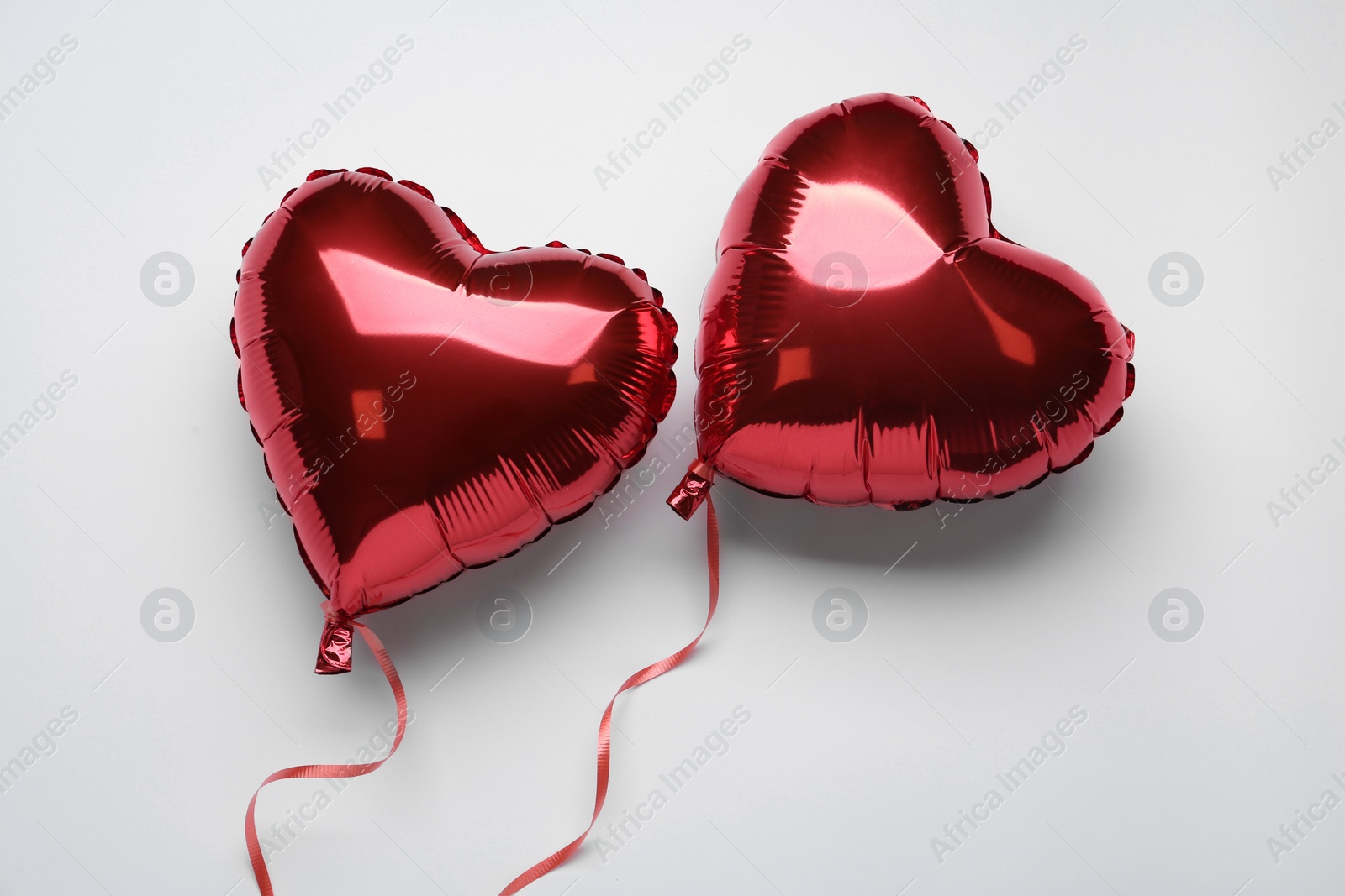 Photo of Red heart shaped balloons on white background, flat lay. Valentine's Day celebration
