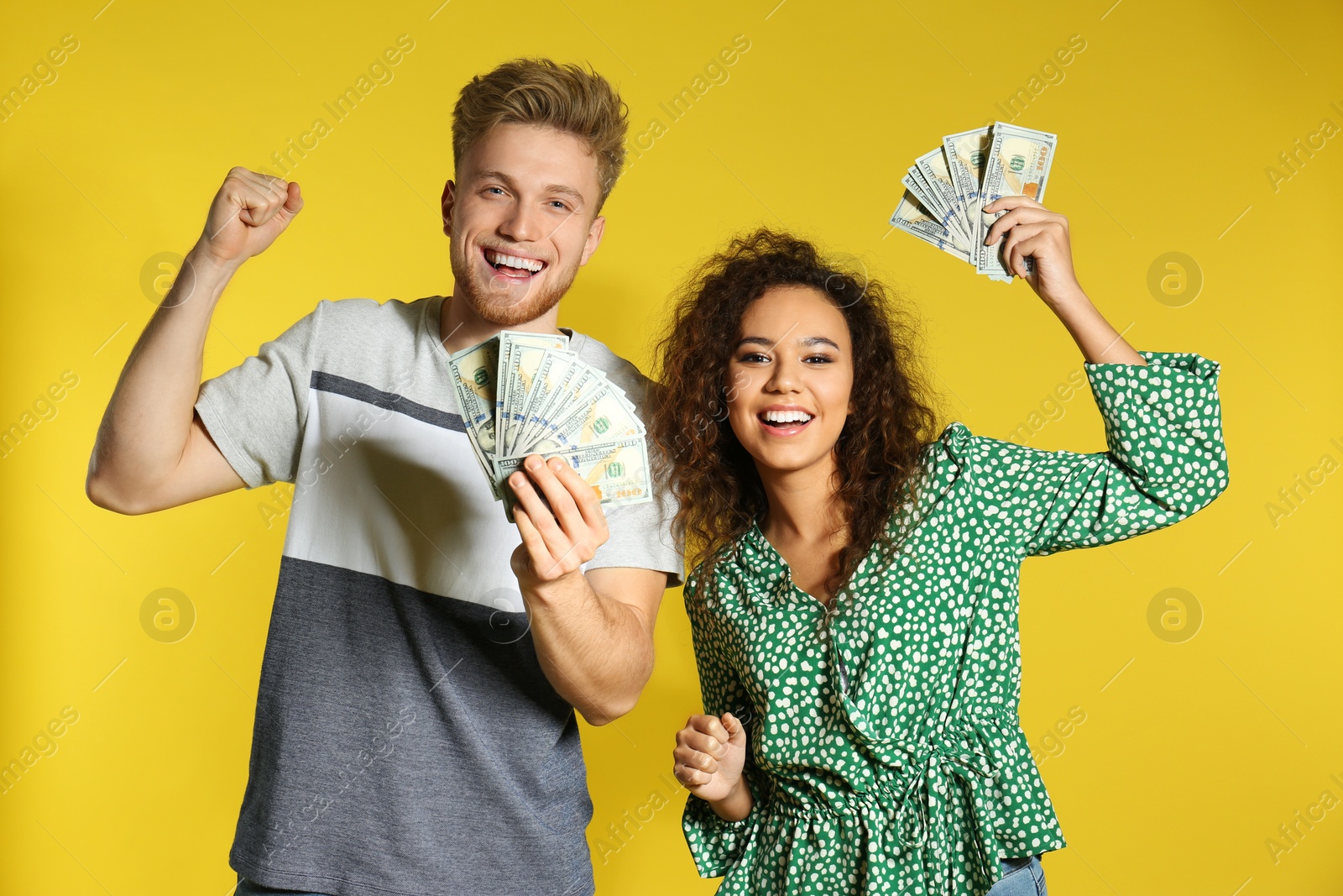 Photo of Young couple with money on color background