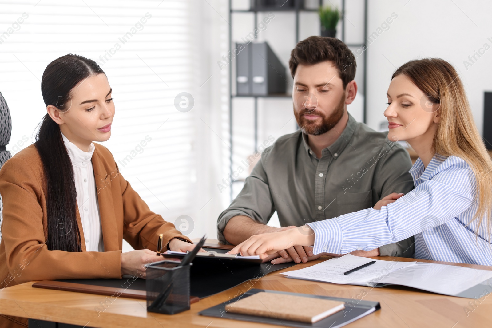 Photo of Couple having meeting with lawyer in office