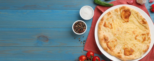 Delicious Megrelian khachapuri served on light blue wooden table, flat lay. Banner design with space for text