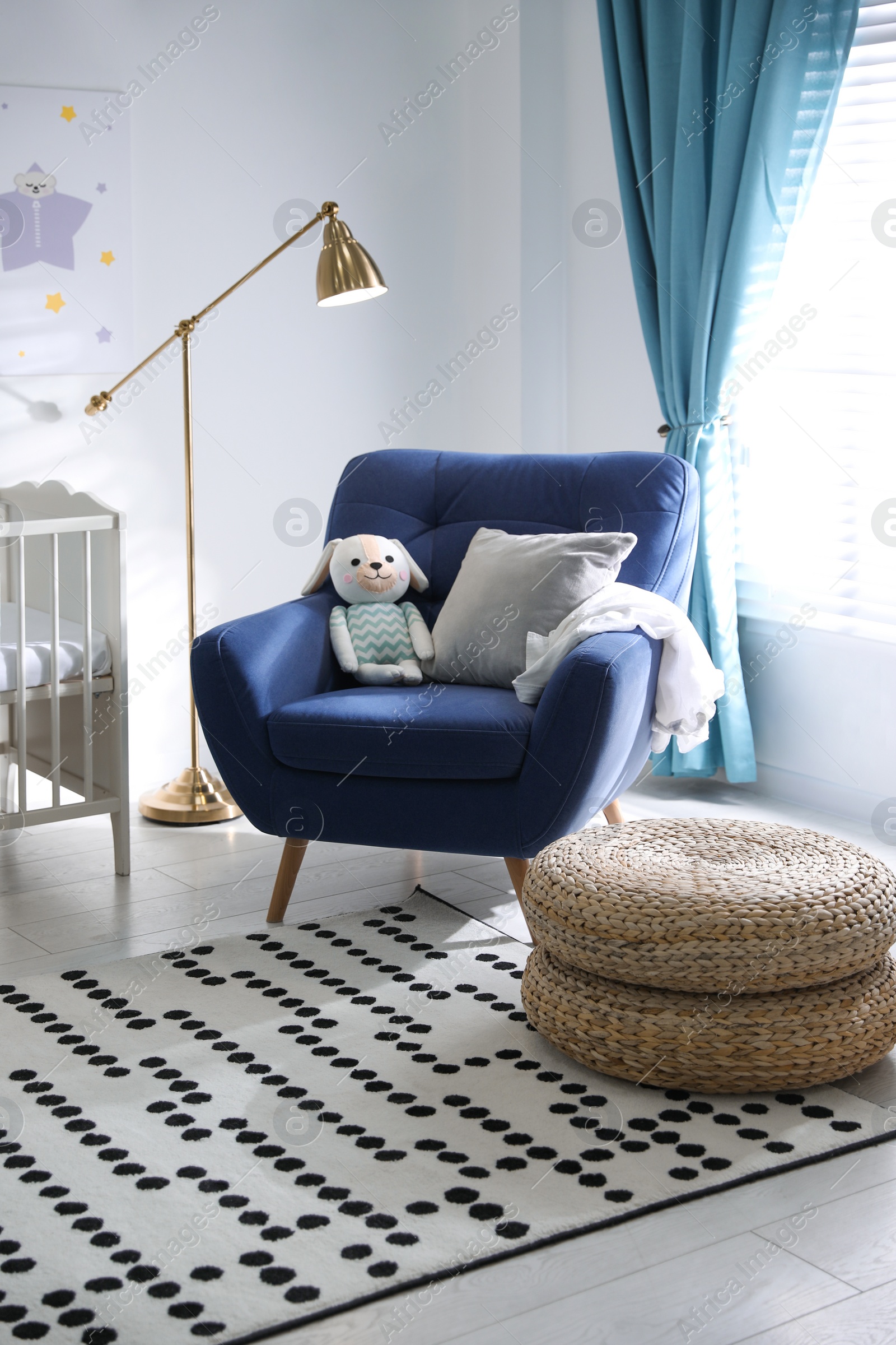 Photo of Cozy baby room interior with comfortable armchair