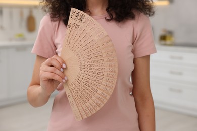 Photo of Woman with hand fan indoors, closeup view