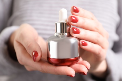 Photo of Woman holding cosmetic product, closeup. Winter care