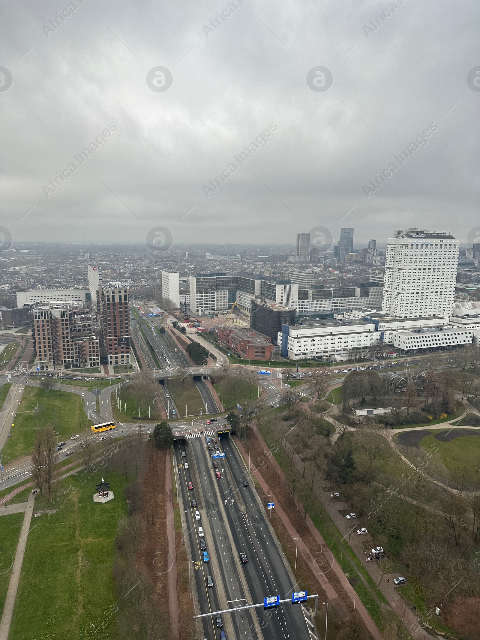 Photo of Picturesque view of city with modern buildings and highway on cloudy day