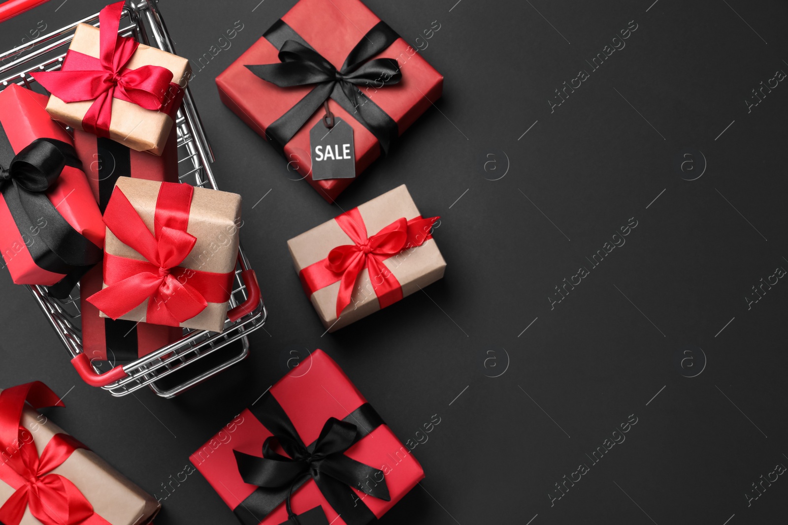 Photo of Cart with gift boxes on dark background, flat lay and space for text. Black Friday sale