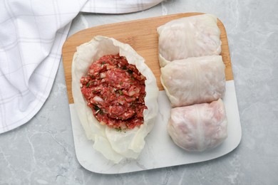 Preparing stuffed cabbage rolls on light grey table, flat lay