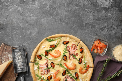 Photo of Delicious seafood pizza on grey table, flat lay. Space for text