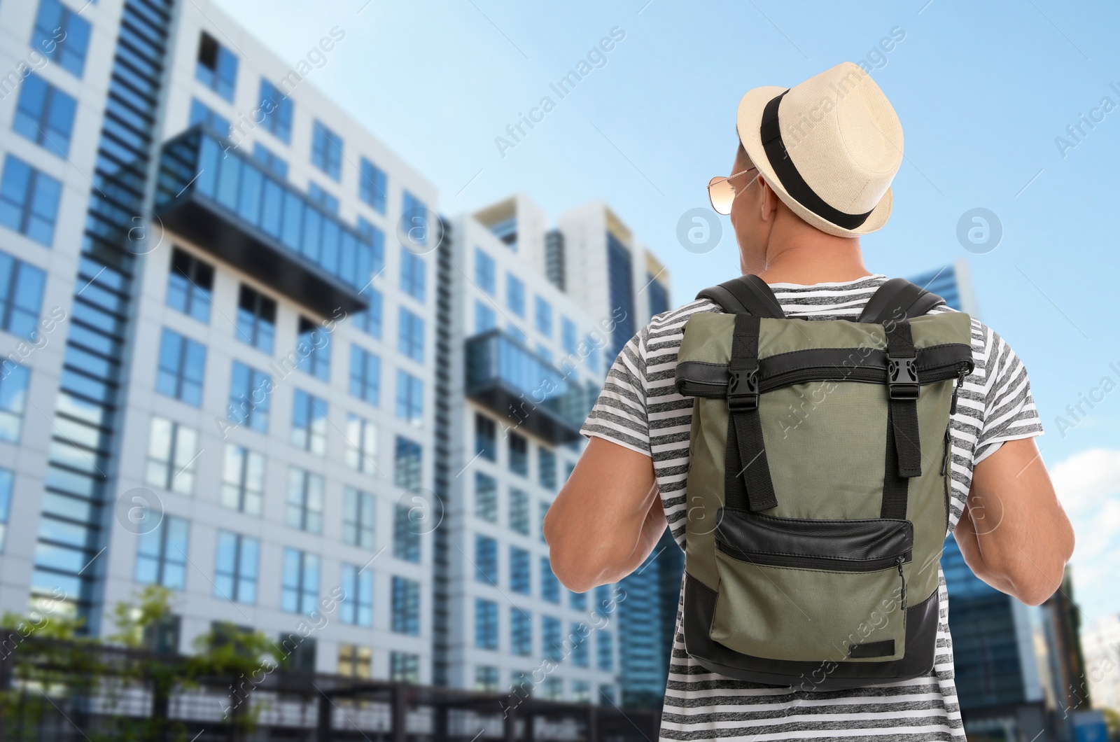 Image of Traveler with backpack in foreign city during summer vacation, back view