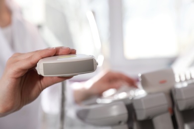 Photo of Sonographer holding ultrasound machine probe in clinic, closeup with space for text