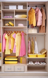 Photo of Stylish clothes, shoes and accessories in large wardrobe closet