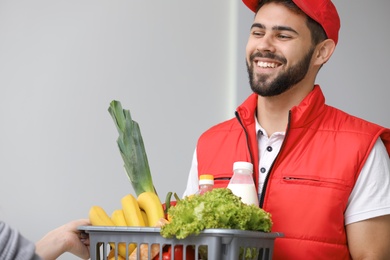 Young man delivering food to customer indoors