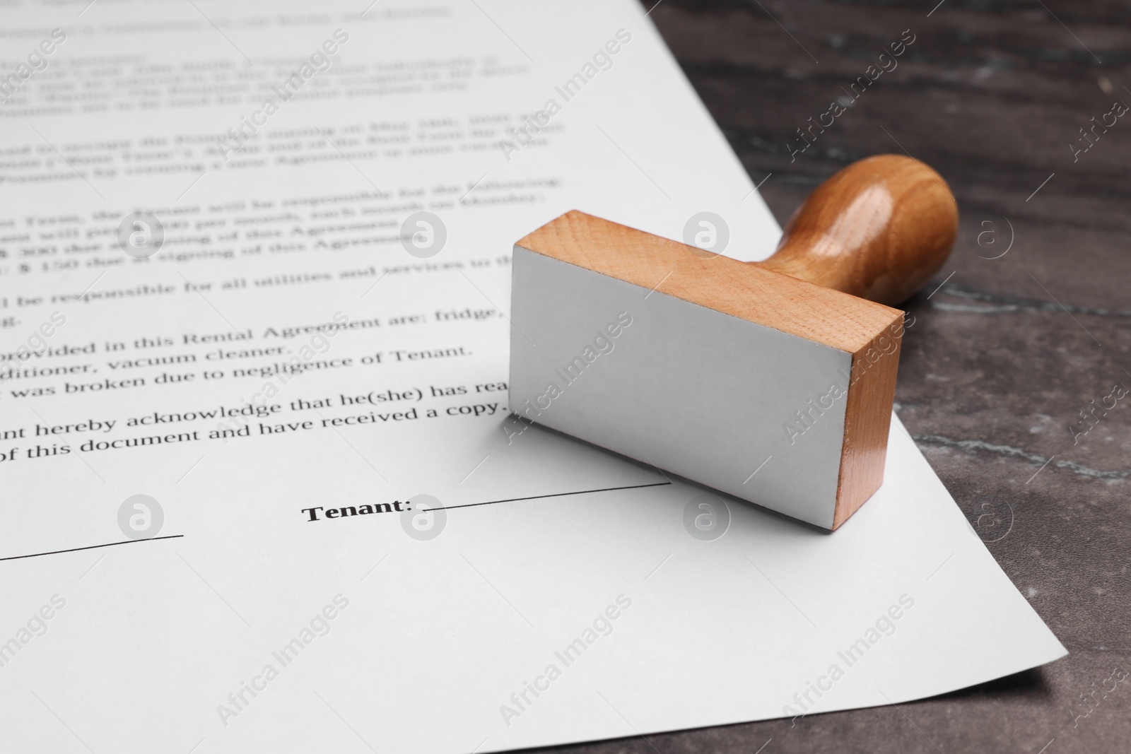 Photo of One stamp tool and document on dark marble table, closeup