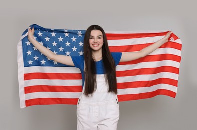 Photo of 4th of July - Independence Day of USA. Happy girl with American flag on grey background
