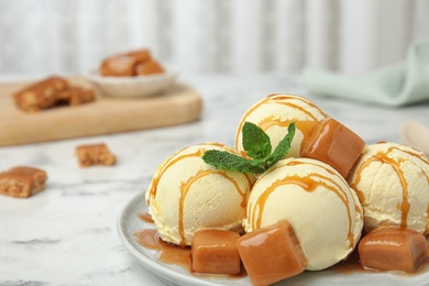 Photo of Delicious ice cream with caramel and sauce served on table. Space for text