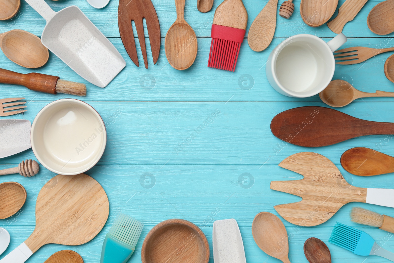 Photo of Frame made with modern cooking utensils on light blue wooden table, flat lay. Space for text