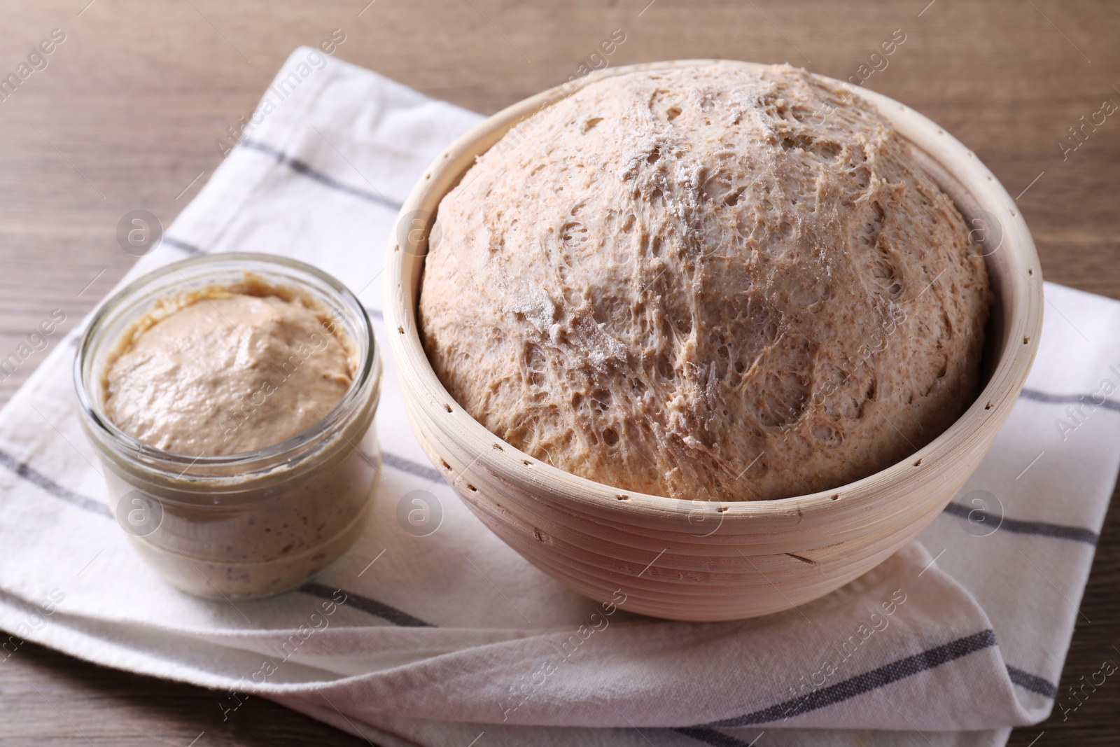 Photo of Fresh sourdough starter and dough on wooden table