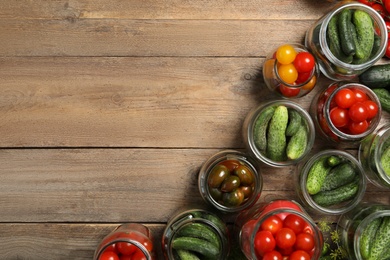 Photo of Pickling jars with fresh vegetables on wooden table, flat lay. Space for text