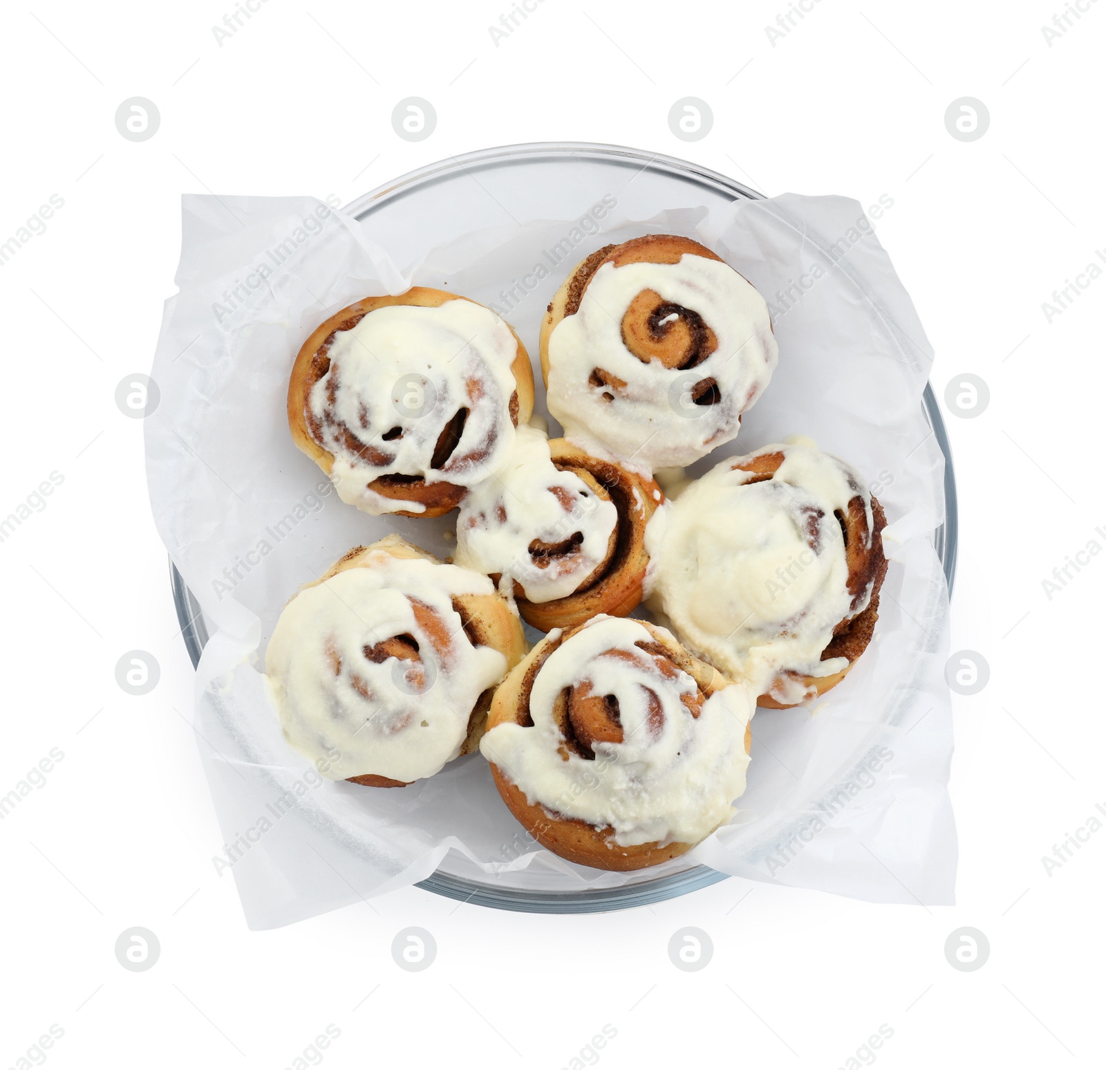 Photo of Tasty cinnamon rolls with cream in baking dish isolated on white, top view