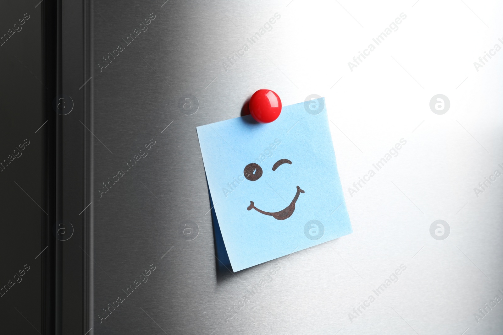 Photo of Note with funny face on refrigerator door